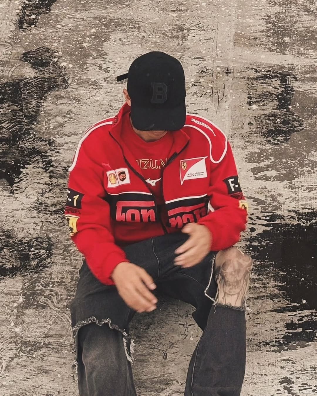 Woman wearing a red Ferrari jacket unisex style with black pants, showcasing streetwear-inspired motorsport apparel outdoors.